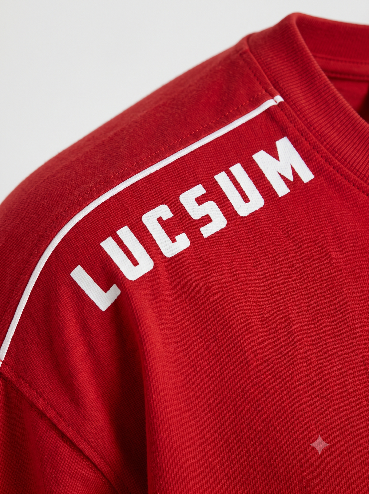 Lucsum Shoulder Logo Red — Macro close-up