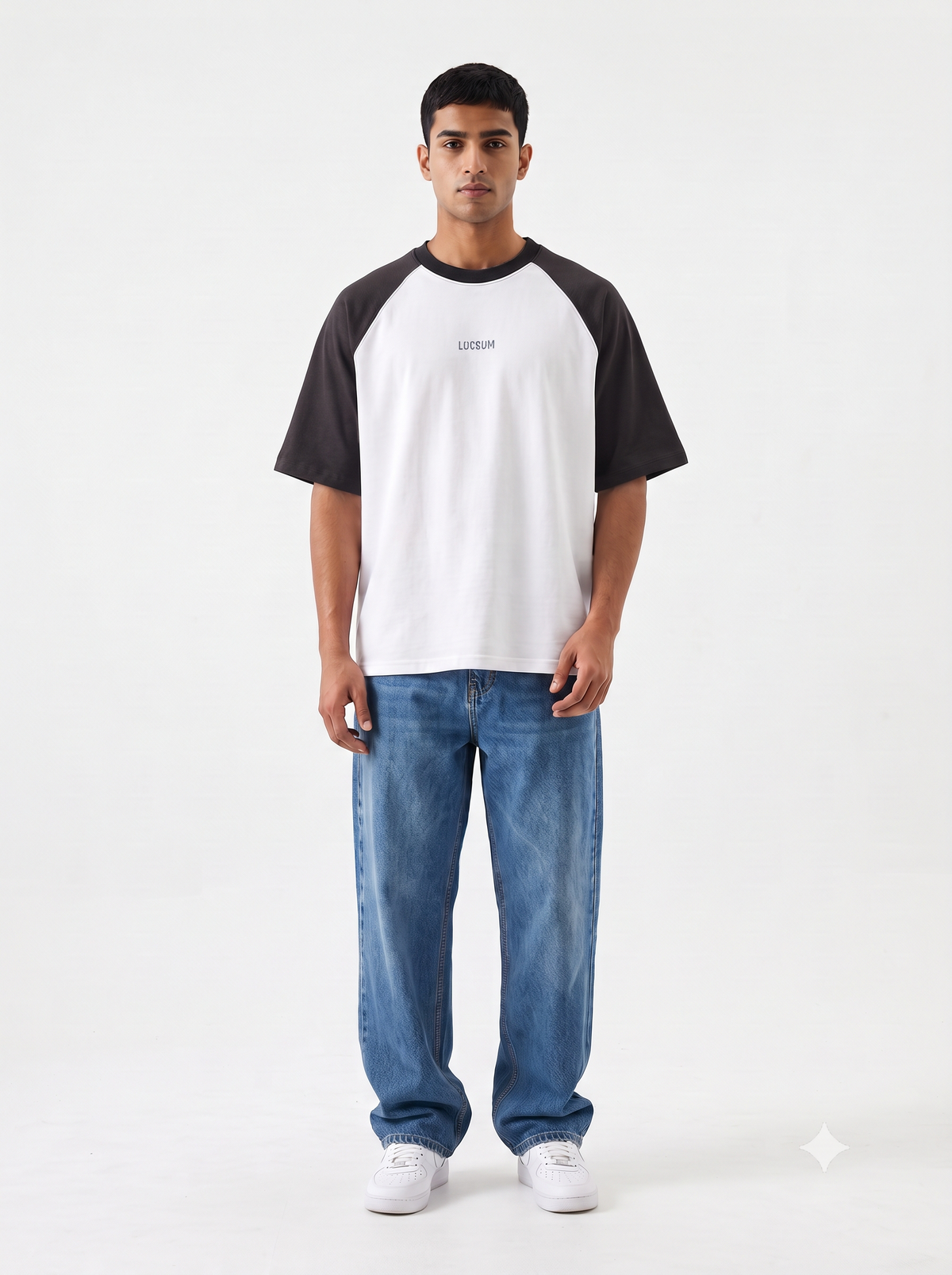 Model wearing Lucsum Raglan white oversized tee with charcoal sleeves and baggy blue jeans, full-length front view