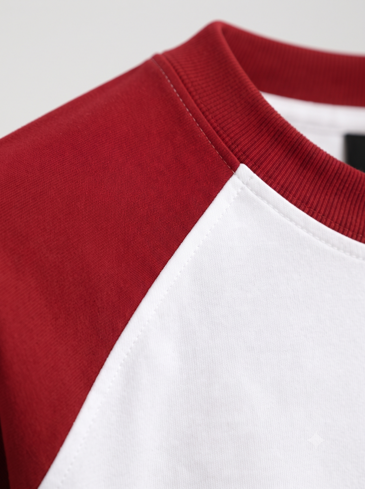 Lucsum Raglan white oversized tee with crimson sleeves and collar, macro raglan seam detail
